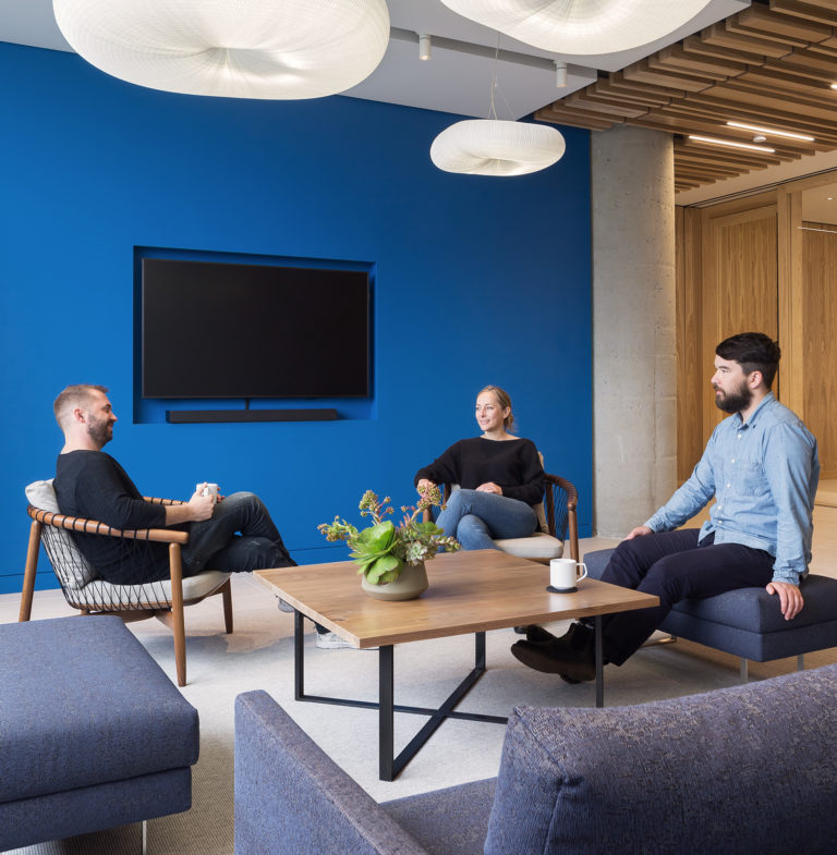 Workers sitting around coffee table talking